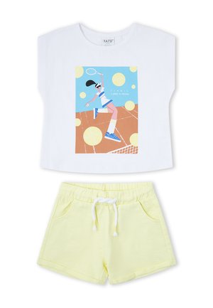 Top blanco sin mangas con gráfico de jugador de tenis combinado con pantalones cortos de tiro elástico y cordón de color amarillo claro.