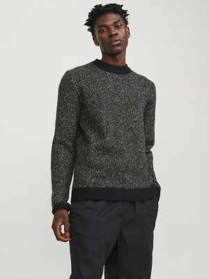 Black and grey marled sweater with a round neckline, ribbed cuffs and hem, featuring a textured knit fabric. Worn with dark trousers.