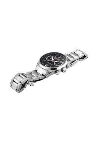 Reloj de pulsera cronógrafo de acero inoxidable con esfera negra, dos subesferas, ventana de fecha y pulsera metálica enlazada, mostrado parcialmente desabrochado.