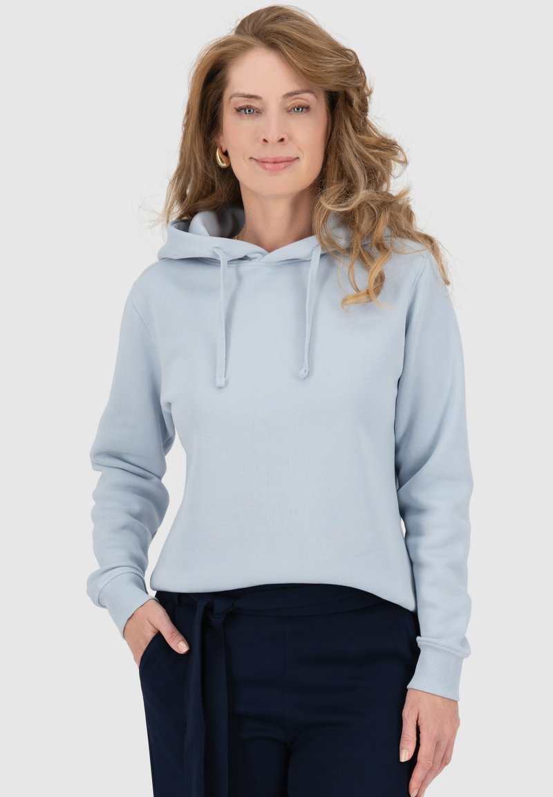 Felpa blue chiaro con cappuccio, nastri di regolazione e tasca a marsupio, realizzata in un morbido cotone misto. Maniche lunghe e polsini a costine. Abbinata a pantaloni scuri.