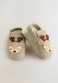 Filzhausschuhe in hellbeige mit einem Rentierdesign; verfügen über ein flauschiges Innenfutter, gesticktes Gesicht und rote Geweih-Akzente. Verstellbarer Riemen an der Rückseite.