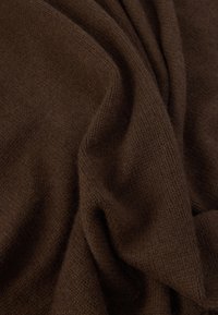 Σκούρο καφέ πλεκτό ύφασμα, μαλακή υφή, με διακριτικές παραλλαγές στον ιστό, ριγμένο και ελαφρώς τσαλακωμένο, παρουσιάζοντας πλούσιο βάθος χρώματος.