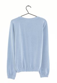 Top de manga larga azul claro con cuello redondeado y puños y dobladillo elásticos, fabricado con una tela suave y lisa.