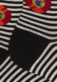 Calzini a righe bianche e nere con motivi floreali colorati con accenti rossi, arancioni e viola. Morbida texture lavorata a maglia.