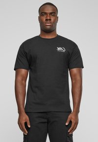 Sort bomulds T-shirt med korte ærmer og rund hals, prydet med hvid logo tekst på venstre brystområde. Enkelt, klassisk design.