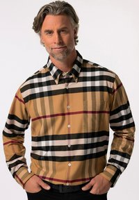 Camisa de cuadros marrón con rayas negras, blancas y burdeos. Presenta un bolsillo, cuello puntiagudo y una textura suave.