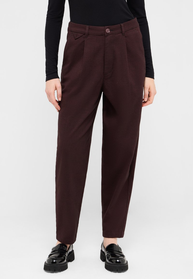 Burgundy tailored trousers with a textured finish, featuring side pleats, a front button closure, and a regular fit. Paired with black shoes.