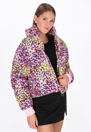  gepolsterte Jacke im mehrfarbigen Leopardenmuster mit glänzender Oberfläche, pinken Bündchen, Reißverschluss und geripptem Saum. Schwarzes Kleid darunter.