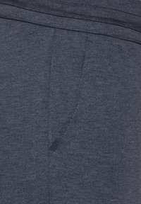 Marineblaue Jogginghosen aus weichem, strukturiertem Stoff mit einem elastischen Bund und seitlichen Taschen. Dezentes meliertes Muster auf der gesamten Fläche.