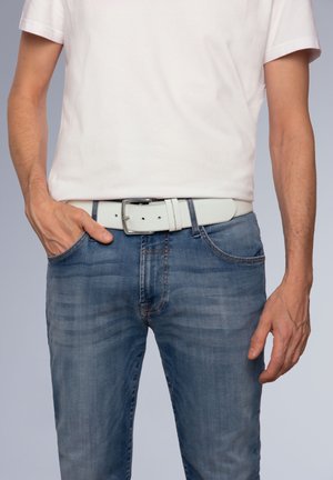 White belt featuring a smooth texture and a silver buckle, worn with blue denim jeans that have a faded wash and stitching accents.
