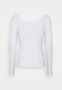 Vit långärmad topp med rundad halsringning, med ribbad textur och figurnära passform. Inga synliga mönster eller metalliska detaljer.