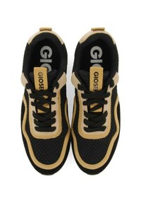 Svarta och beige träningsskor med övre i mesh, vadderad krage och svarta snören. Har en gul logotagg på tungan.