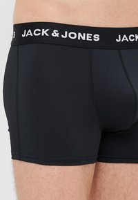Sorte boxer briefs med en myk elastisk midje som har "JACK & JONES" logo i hvitt. Glatt tekstur, tettsittende form, og minimalistisk design.