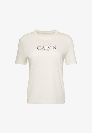 T-shirt blanc à manches courtes et col rond avec "CALVIN" en grandes lettres noires et "Calvin Klein" en texte rouge plus petit en dessous, sur la poitrine.