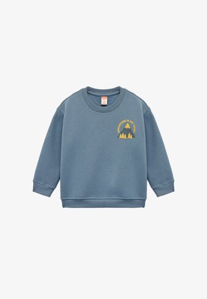 Sininen huppari, joka on valmistettu pehmeästä kankaasta, jossa on pitkät hihat ja ribbauskaulus. Etupuolen graafisessa kuvastuksessa on vuoria ja teksti "SEIKKAILU ON ULKONA."