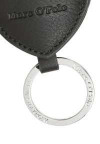 Zwarte leren sleutelhanger met een hartvormige tag, voorzien van het reliëf "Marc O'Polo" logo en een ronde zilveren metalen ring met gegraveerde details.