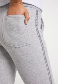 Graue Sweatpants mit einer Tasche, elastischem Taillenbund und seitlichem Streifen mit "bruno banani"-Logo. Weicher Stoff mit lässiger Passform.