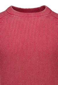 Zbliżenie na czerwoną i różową dzianinę prążkowaną z okrągłym dekoltem i fakturowanym pionowym wzorem ściegów.