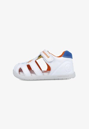 Sandalias sintéticas blancas con forro naranja, detalle de tacón azul, diseño abierto con cortes, correa ajustable y suela texturizada.