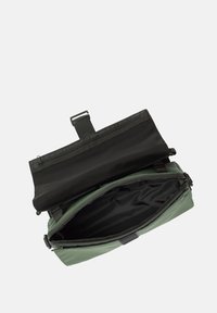 Borsa impermeabile verde con interno nero, chiusura a zip e tracolla. Presenta una superficie liscia e un ampio scomparto principale.