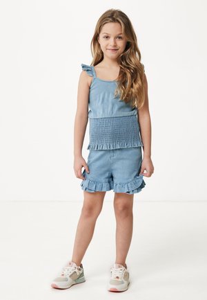 Denim tweedelige set met een gesmokte tanktop met franje schouderaccenten en bijpassende shorts met gerimpelde zomen. Lichtblauwe kleur.