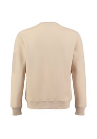 Beżowy, teksturowany sweatshirt z ściągaczem przy dekolcie i mankietach. Wykonany z miękkiej, tkanej tkaniny oraz posiada naszywkę na lewym rękawie.