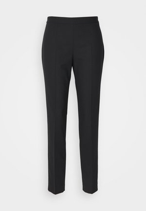 Sorte skræddersyede bukser med en glat tekstur, slim fit og en flad linning. Ingen synlig hardware; sømmene skaber en strømlinet silhuet.