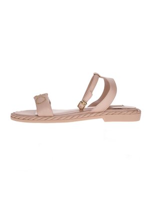 Jasnoróżowe sandały na płaskiej podeszwie, z plecionym detalem na podeszwie, pojedynczym paskiem z złotym okrągłym akcentem oraz regulowanym paskiem na kostkę.