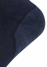 Calcetín de color azul oscuro con un patrón de punto texturizado. El talón presenta una zona reforzada para mayor durabilidad y una transición suave hacia la sección de la pierna.
