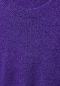 Close-up of a purple knitted sweater showing the ribbed crew neckline and textured fabric pattern.