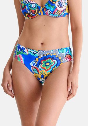 Femme portant un bikini bleu à motif floral coloré, mettant en avant la taille et les hanches sur un fond blanc uni.