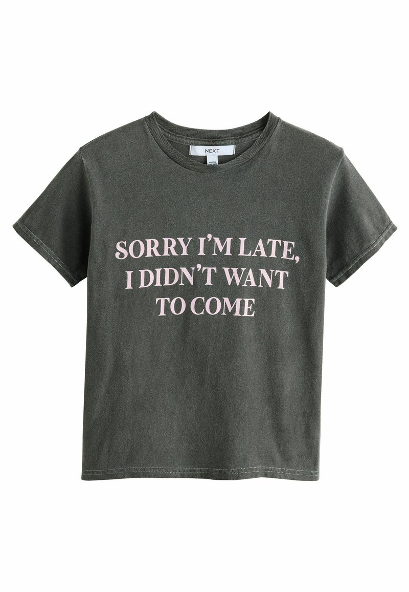 T-shirt gris à manches courtes avec un grand texte rose : "DÉSOLÉE D'ÊTRE EN RETARD, JE NE VOULAIS PAS VENIR." Style décontracté et coupe relax.