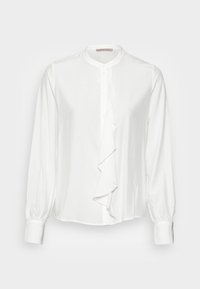 Blusa bianca con colletto alto, chiusura frontale con bottoni e dettaglio di rouches a cascata lungo la patta. Maniche lunghe e arricciate con polsini.