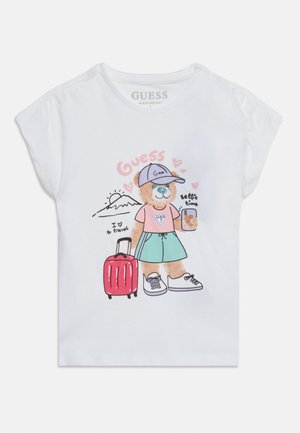 Λευκό μπλουζάκι με ένα καρτούν αρκουδάκι που φοράει καπέλο, μπλουζάκι, σορτς, κρατάει ένα τηλέφωνο και τραβάει μια κόκκινη βαλίτσα με ζωγραφιά βουνού και καρδιών.