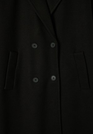 Cappotto doppiopetto nero realizzato in lana, con due tasche frontali e bottoni neri. Texture liscia e design del colletto classico.