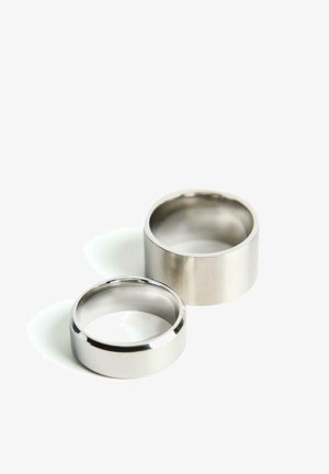 Prikazana sta dva prstana: eden je poliran srebrn pas z ozkim profilom, drugi pa je mat srebrn pas z širšim profilom.