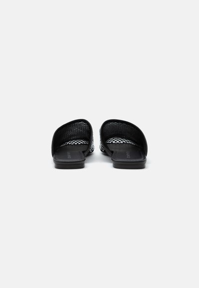 Paire de sandales ouvertes noires à enfiler avec tige en mesh et semelle plate, vues de dos sur fond blanc.