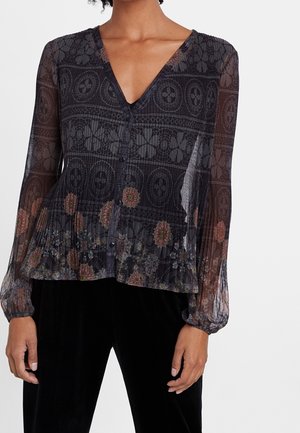 Doorschijnende zwarte bloemenblouse met V-hals, knopen aan de voorkant, lange opgeblazen mouwen en een geplooide taille, gedragen met een zwarte broek.