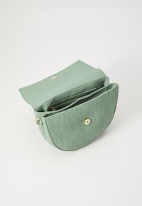 Borsa in pelle verde goffrata con una forma arrotondata, dotata di una patta anteriore, hardware dorato e due scomparti interni per la gestione degli oggetti.
