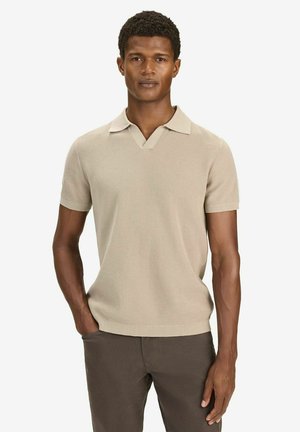 Beige strik polo-shirt med korte ærmer, der har v-udskæring og kontrasterende krave. Bæres med brune bukser.