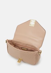Borsa beige trapuntata con interno liscio, dotata di chiusura con fibbia in metallo dorato e tasca con zip. Chiusura a ribalta esagonale inclinata.