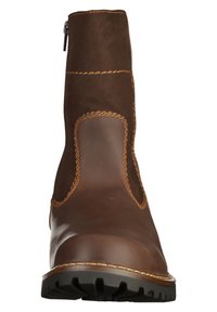 Botín de cuero marrón con acentos de ante, detalles de costuras prominentes, una cremallera lateral y una suela de goma texturizada.