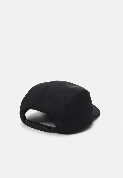 Casquette noire en tissu texturé, avec une visière incurvée et une sangle ajustable arborant un logo en relief. Le design comprend des coutures visibles et une silhouette douce.