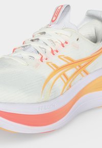 Άσπρο και πορτοκαλί παπούτσι για τρέξιμο Asics με λευκά κορδόνια, πορτοκαλί λογότυπο και μαλακή σόλα με πορτοκαλί και κίτρινες λεπτομέρειες.