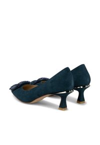 Décolleté in suede blu scuro con punta arrotondata e decorazioni, dotate di un tacco basso e dettagli metallici per stabilità.