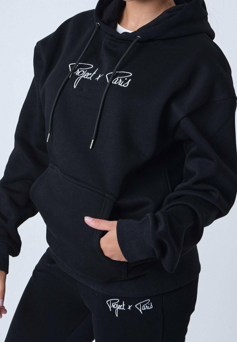 Sweat à capuche noir avec cordons de serrage, poche kangourou et logo brodé "Project x Paris". Tissu doux ; larges poignets et détail à l'ourlet.