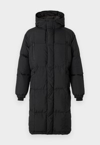 Abrigo acolchado negro con un cuello alto, cremalleras ocultas, puños elásticos y bolsillos laterales. Forma rectangular, textura suave y diseño aerodinámico.