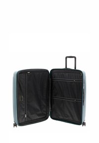 Valigia rigida di colore azzurro con manico retrattile e quattro ruote. L'interno è dotato di rivestimento in tessuto nero, tasche con zip e divisori in rete.