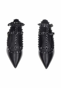 Ballerine nere a punta con un design di fascette borchiate. Realizzate in pelle liscia con una finitura lucida e cinturini alla caviglia regolabili.