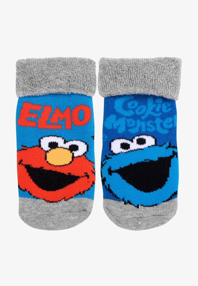 Calzini per bambini con i personaggi Elmo e Cookie Monster. Realizzati in tessuto a maglia, nei colori rosso e blu, con dettagli in terry grigio sul polsino.